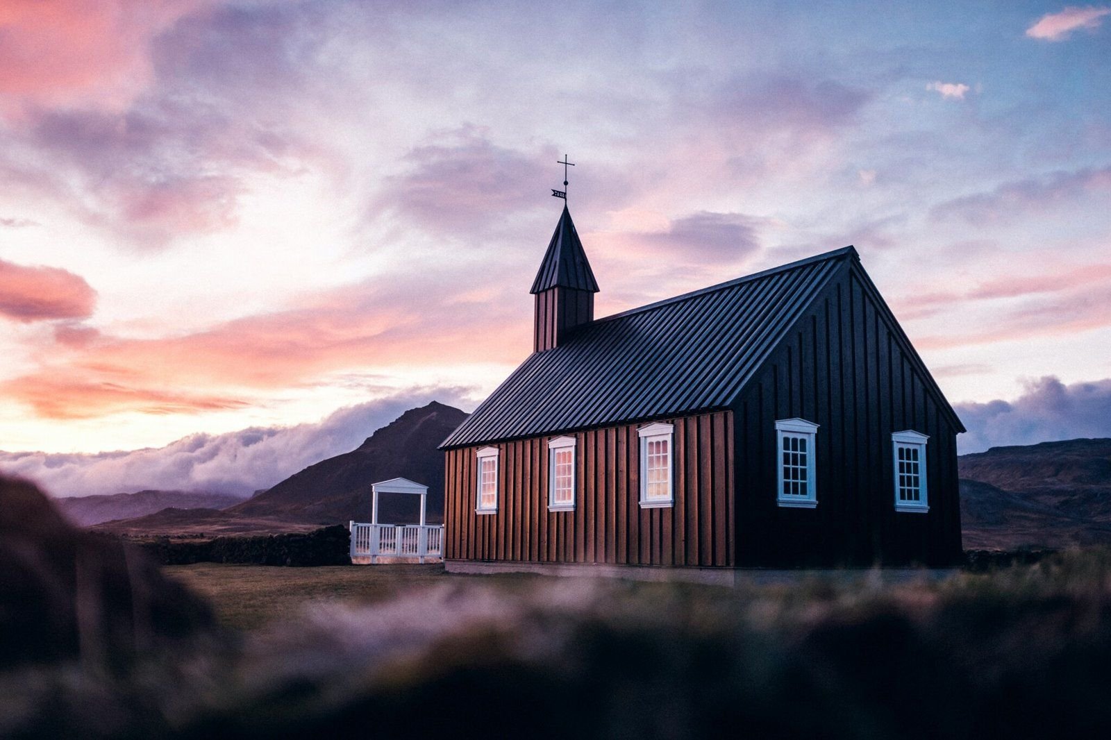 A small church at dusk, windows glowing with warm light